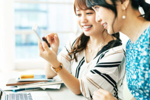 女性 2人 パソコン スマホ 笑顔